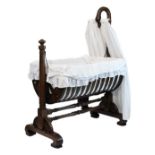 Victorian mahogany rocking crib, the raised head support formed as the bowed head of a swan,