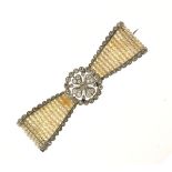 Diamond and seed pearl bow brooch, the central quatrefoil cluster within a border, flanked either