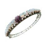 Opal and ruby hinged bangle, unmarked, the frontispiece with a graduated row of sixteen opals and