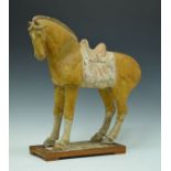 Early Chinese Tang style pottery figure of a horse having a mustard coloured partially glazed
