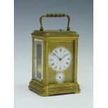 19th Century engraved brass gorge cased repeat carriage clock, the white enamel dial with Roman