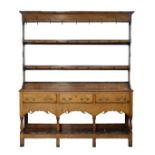 18th Century oak high dresser, the open backed plate rack having moulded cornice, fitted three