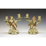 Pair of 18th Century Chelsea porcelain figural two branch candelabra, each formed as a seated