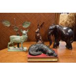 Cold cast resin figure of a sleeping dog on a book, resin figure of a hare, carved wooden elephant