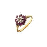 18ct gold daisy cluster ring, the central diamond surrounded by ruby coloured stones, size L