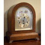 Early 20th Century oak arch cased mantel clock, the silvered dial with Arabic numerals, subsidiary