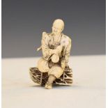 Early 20th Century Japanese carved ivory okimono formed as a man seated on a bundle of twigs
