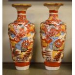 Pair of early 20th Century Satsuma earthenware vases, each decorated with figures in a landscape