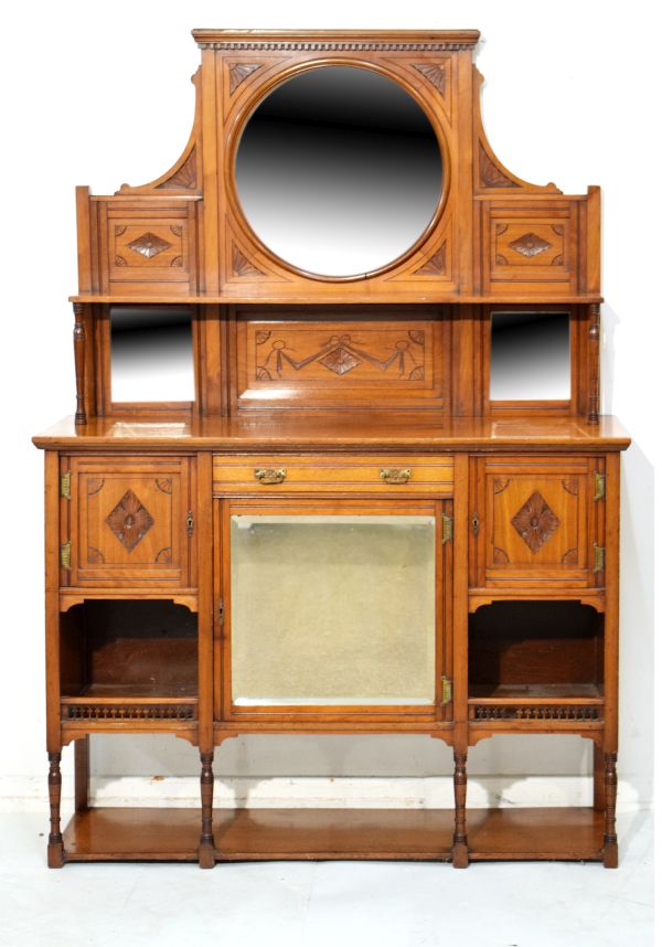 Late Victorian carved walnut chiffonier, the raised back fitted three bevelled mirrored panels, open