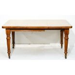 Edwardian oak rectangular extending dining table fitted one insertion and standing on tapered turned