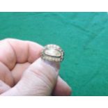 An early 19th century gold metal memorial ring set with seed pearls (some missing).