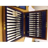 A set of 12 silver-bladed dessert knives and forks with Mother-of-Pearl handles in oak case.