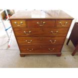 An antique chest of 3 long and 3 short drawers with drop brass handles and brass escutcheons on