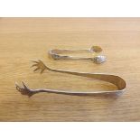 Two pairs of silver sugar tongs, one with claw decoration, the 2 weighing approximately 1.3 troy oz.