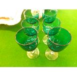 Six green glass pedestal wine glasses with clear glass stems and bases from the late 19th century.