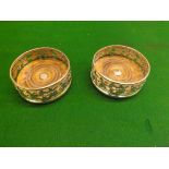 A pair of silver-plated wine coasters with embossed oak leaf decoration on turned wooden bases, 6"