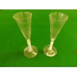 A pair of antique pedestal wine flutes with double twist stems and pontil marks, 8" high.