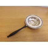 A silver tea strainer with turned wooden handle, hallmarked Birmingham 1944, A/F.