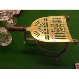 A Victorian brass and wrought iron trivet with wooden handle.