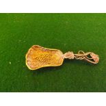 A small silver caddy spoon with gilt bowl and vine decoration.