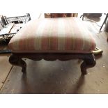 A small antique stool on cabriole legs with striped cover.