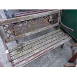 A cast iron garden bench with wooden slats.