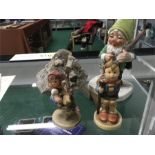 Three Hummel gnome figures and crystal stone.