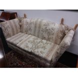 A Three seater knoll settee upholstered in floral fabric.