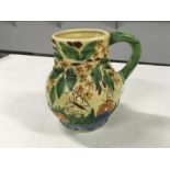 A Wadeheath Deco jug with flowers and butterflies.