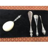 An unusual antique egg shaped earner for sock with silver embossed handle plus three other silver