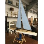 A wooden Marblehead pond yacht with sails.