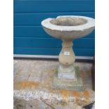 A stone bird bath in three sections.