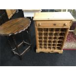 An oval topped oak table on barely twist legs and a pine wine rack with fitted drawer.