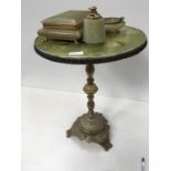 A brass and onyx topped table with cigarette box, ashtray and lighter.
