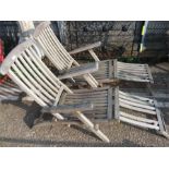 A set of two teak and brass steamer chairs.