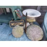 A garden "Welcome" sign, two mushrooms and a clock planter.