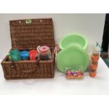A picnic hamper with various plates, bowls, ice cream dishes and cutlery.