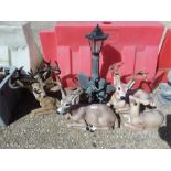 A garden solar light together with deer garden ornaments.