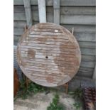 A folding teak circular garden table.