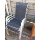 Three stacking aluminium garden chairs.