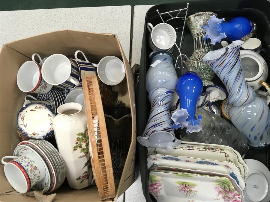 A suitcase containing glassware and various china together with pictures.