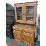 An oak dresser with glazed top and two drawers below.