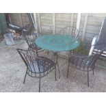 A circular metal garden table and four chairs.