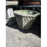 A concrete planter with stone effect.