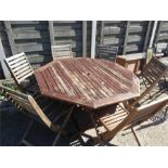An octagonal folding garden table and six chairs.
