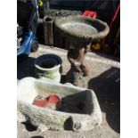 A squirrel columned birdbath with concrete planters.