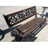 A cast iron garden bench with wooden slats.