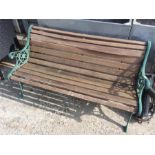 A cast iron garden bench with wooden slats.
