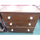 A pine chest of three drawers fitted with ceramic handles.