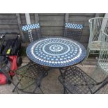 A tiled top garden table and four chairs.